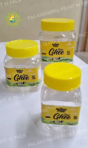 Three clear jars with yellow lids and printed ghee labels.