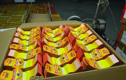 A carton packed with bundles of printed yellow tags.