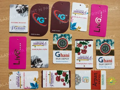 Printed garment and saree tags laid out on a wooden table