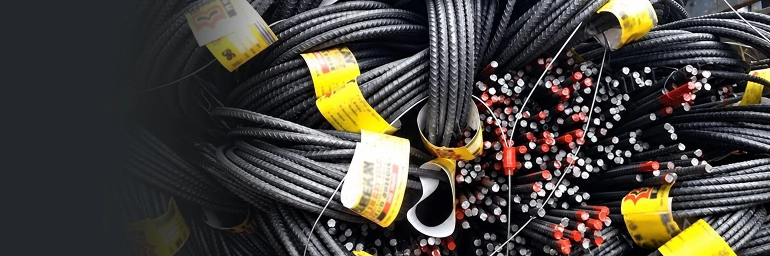 Yellow stick-on tags wrapped around coils of steel bars, the cut bar ends painted red